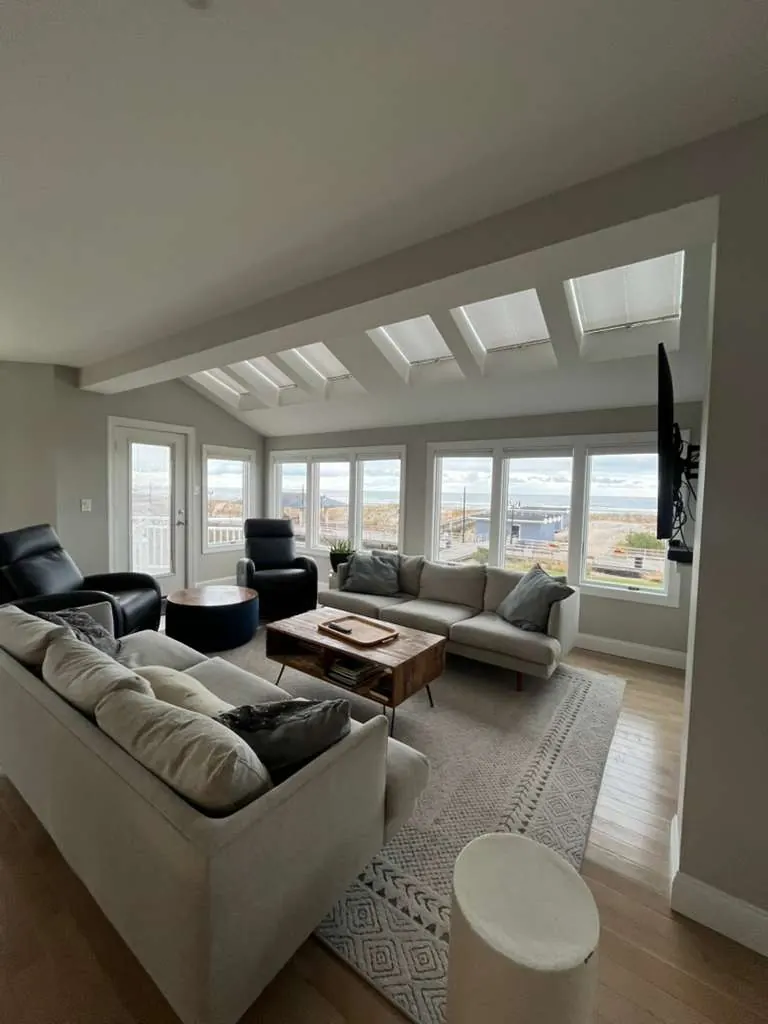 Finished coastal living room with skylights, clean walls and ocean views